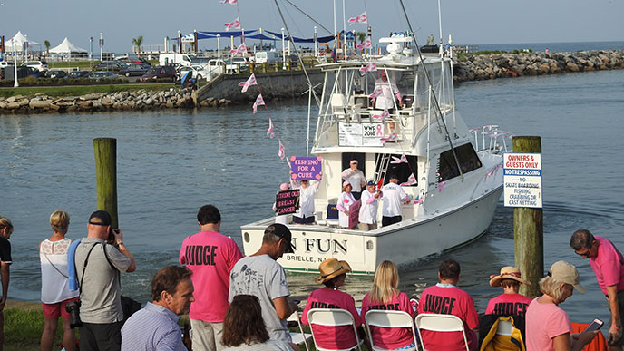 Wine, Women and Fishing attendees watch from the dock as a boat motors away. This is a women’s-only fishing tournament that raises funds for breast cancer research each August at Rudee Inlet in Virginia Beach.