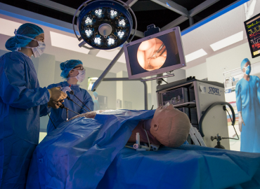 An operating table simulation with two students performing surgery on dummy.