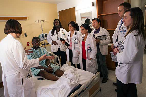 A team of residents visits with a patient