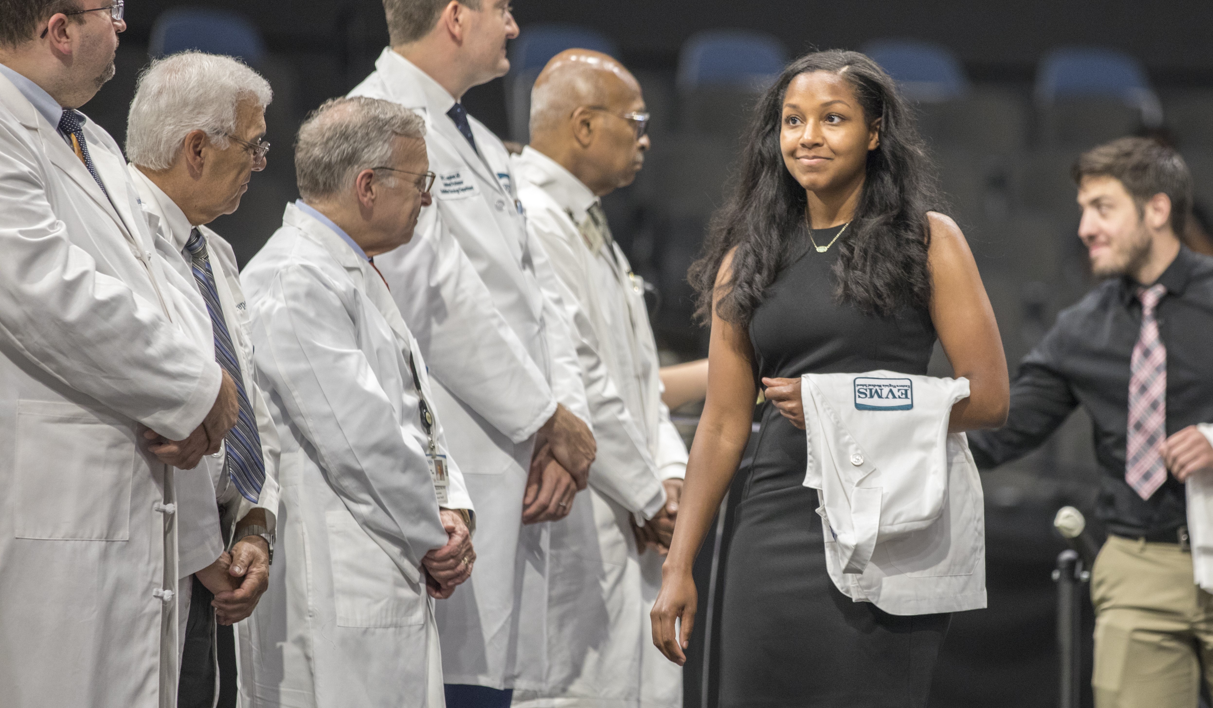 An EMVS student looks proud while walking across the stage during the 2019 MD White Coat Ceremony