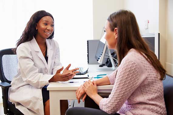 A physician talks with a clinical trial participant.