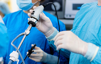 Doctor holding a laparscopic surgery tool with scrubs