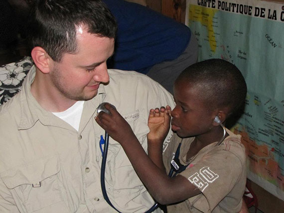 A child listens to a fellow's heartbeat through a stethoscope in Haiti.