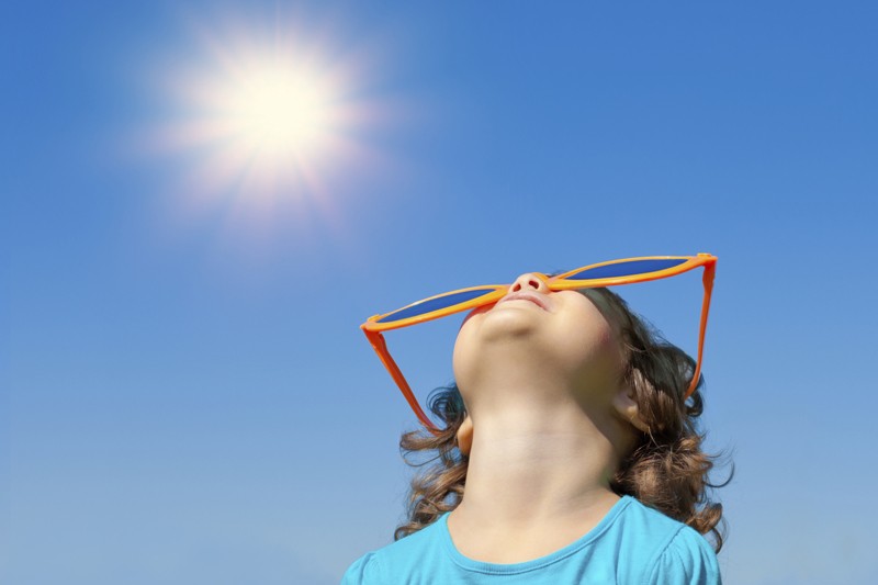 Child staring into the summer sun.
