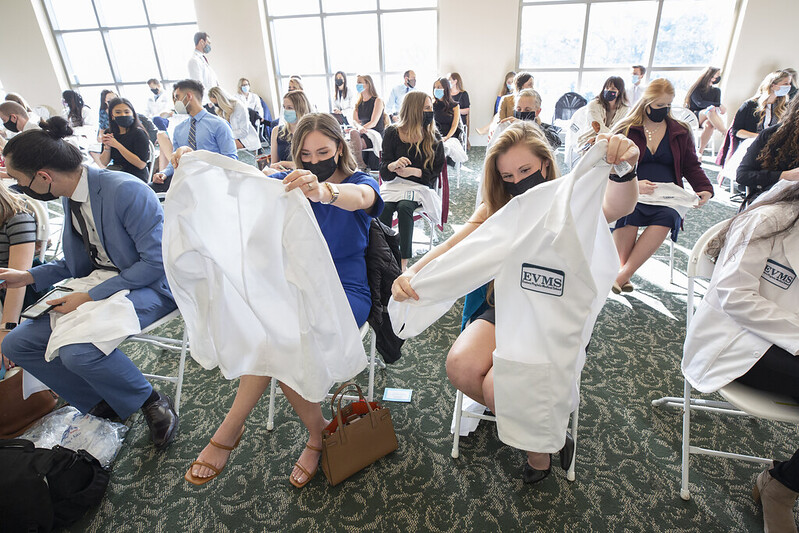 Members of the PA White Coat Class of 2024 hold up their jackets