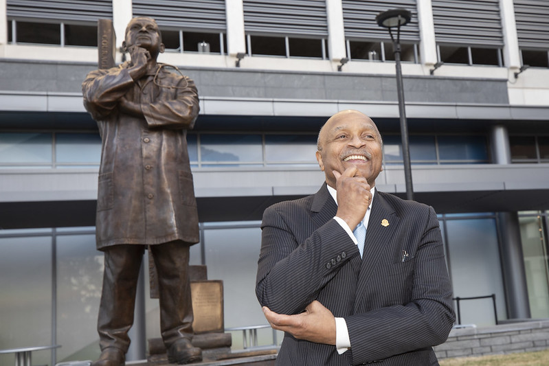 Dr. L.D. Britt stands in front of his statue on the EVMS campus