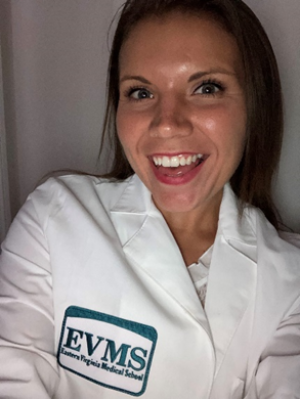 Katie Kolb smiles at the camera wearing her white coat