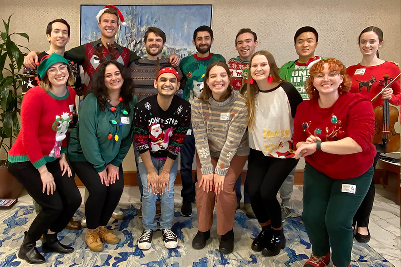 Singing group members in holiday sweaters