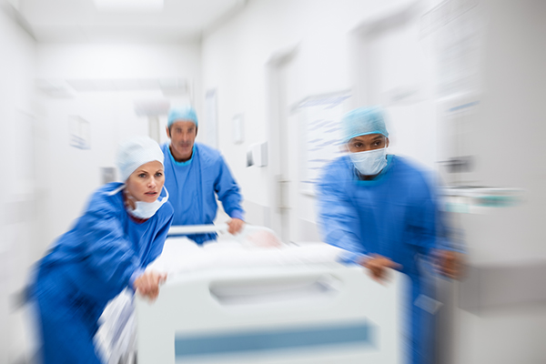 doctors running with patient to surgery down hallway