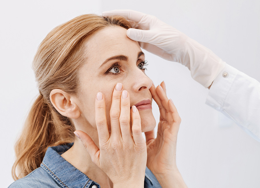 A woman's face is examined by a doctor