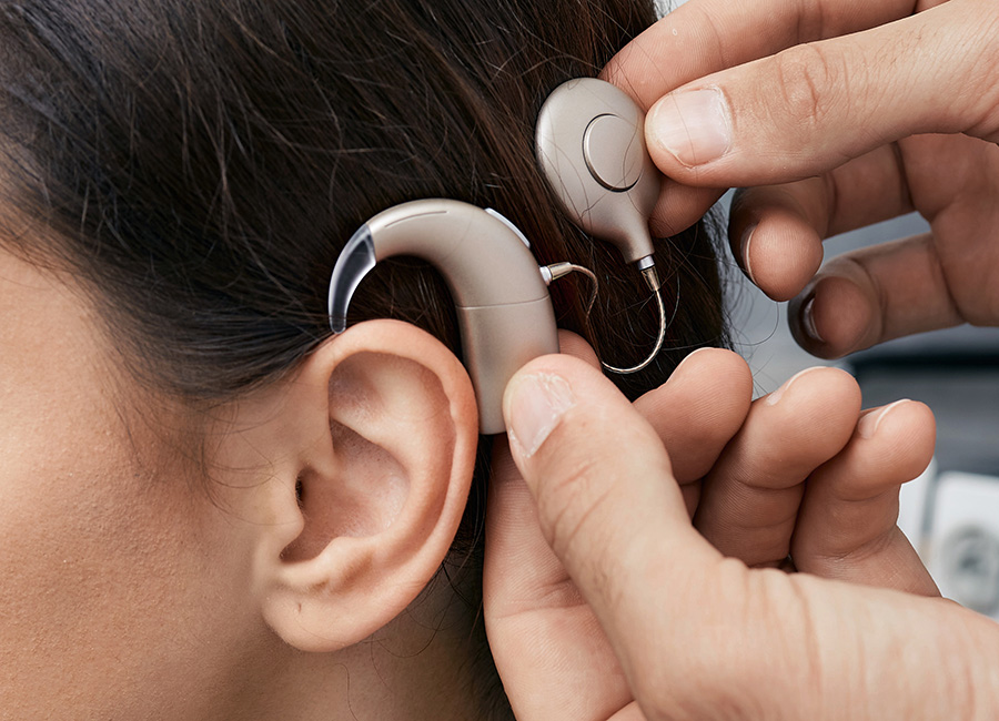 A woman patient is being fitted for a hearing device