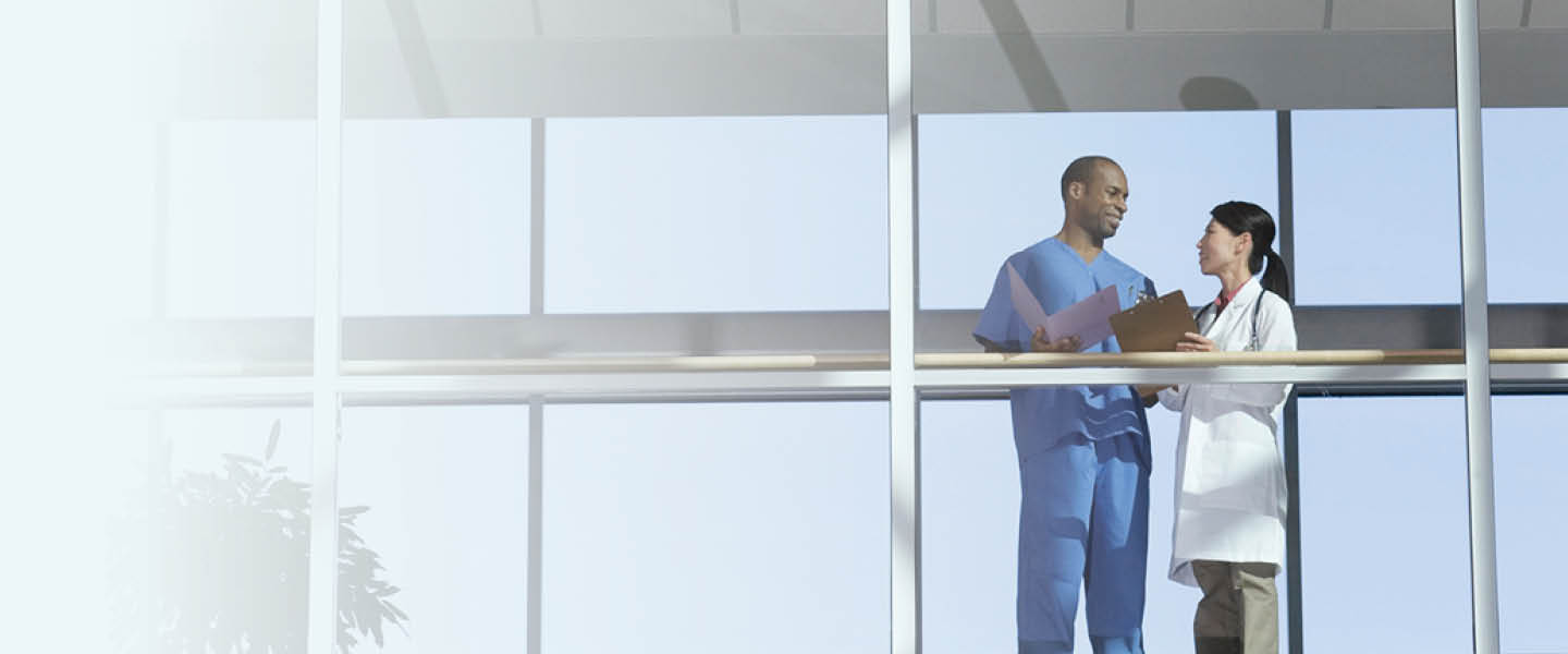 Two medical professionals having a conversation in a walkway