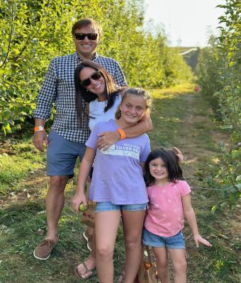 Alumnus, Kelly W. Brown poses with her husband and two daughters on a nature trail
