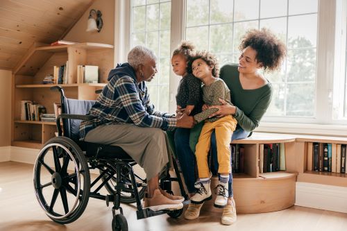 Black woman in wheelchair talks with daughter and grandchildren