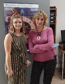 Two females, one younger, stand next to each other.