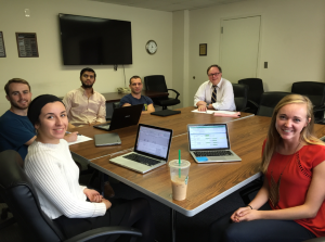 Musto and students around a conference table