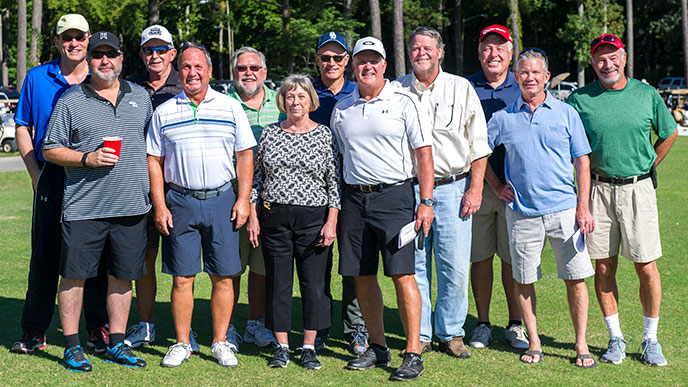 The Coach Ray Barlow “Believe in Yourself” Foundation, whose team is posing for a photo on a golf course, raises funds for Prostate Cancer Research in memory of their beloved Coach Ray Barlow.