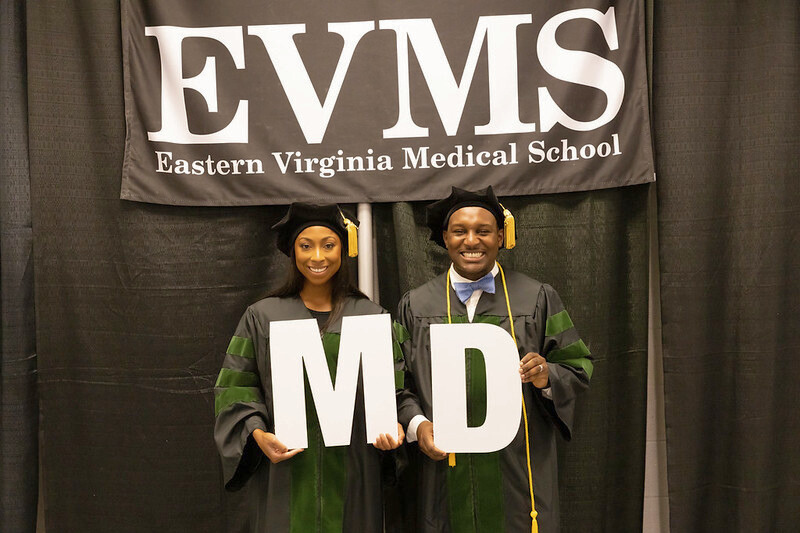 Two African American EVMS students hold the letters M and D