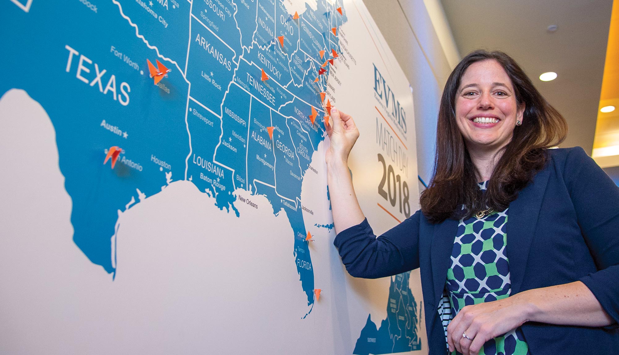 An MD student places her marker on a map for Match Day.