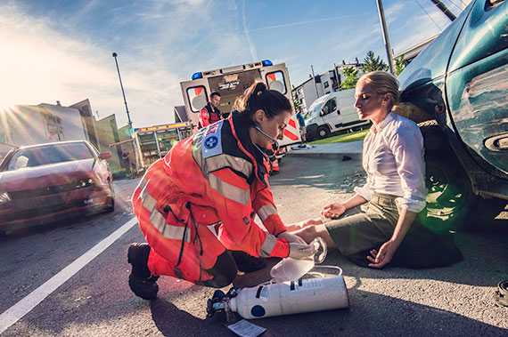 An EMS team assists a patient in an outdoor setting.