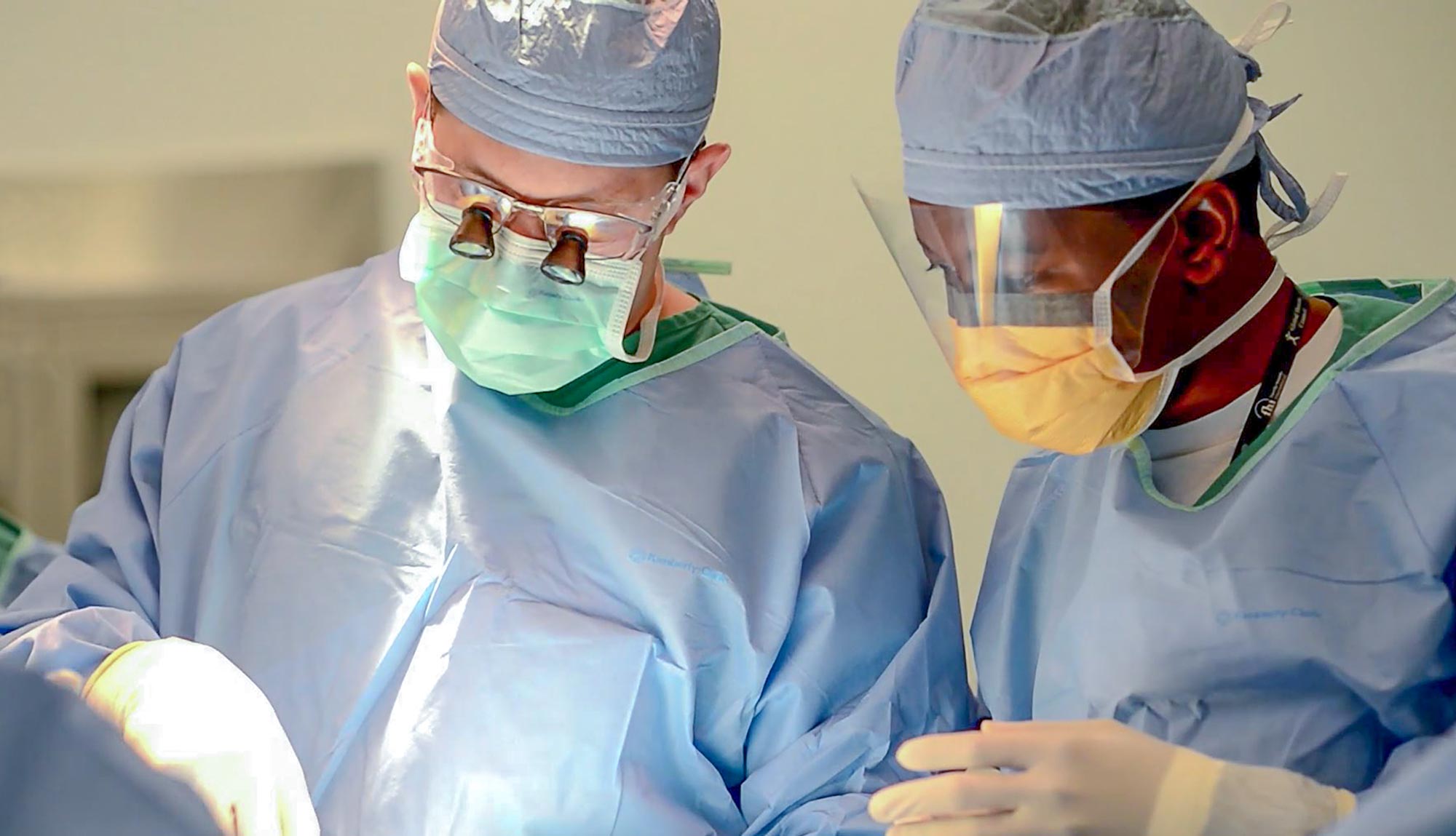 A surgical assistant works with a team in the operating room.