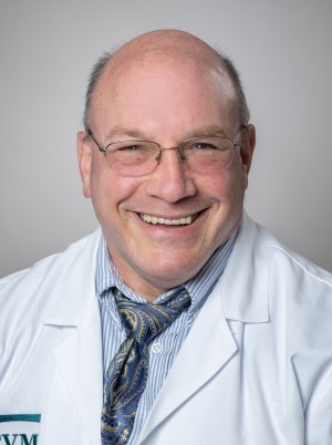 Headshot photo of Dr. Seth Berney smiling for the camera in his white coat.