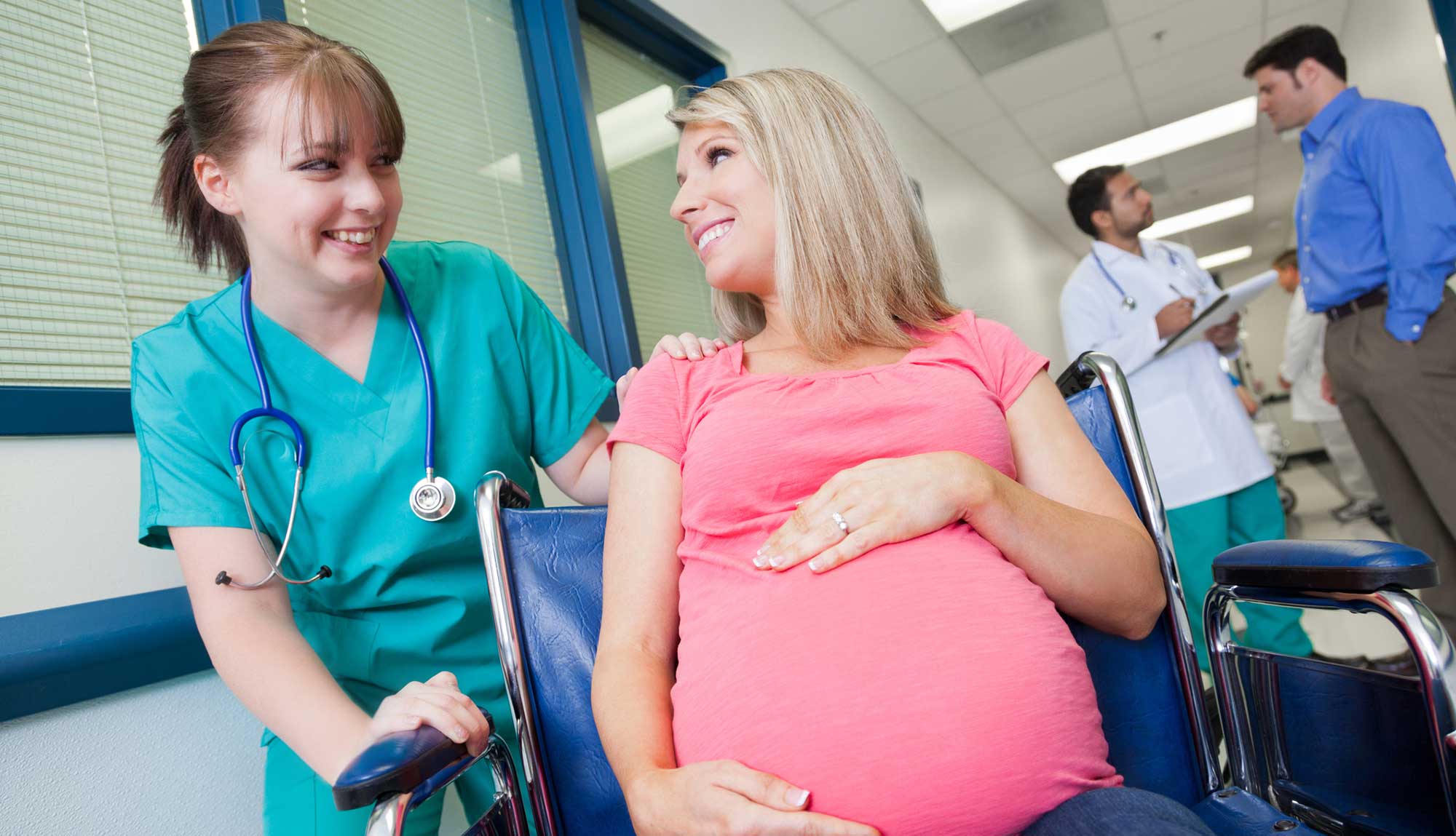 A medical professional talks with a pregnant patient.