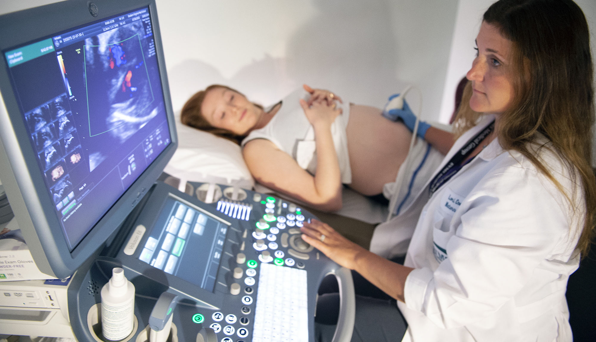 An ultrasonographer performs an ultrasound on a pregnant patient.