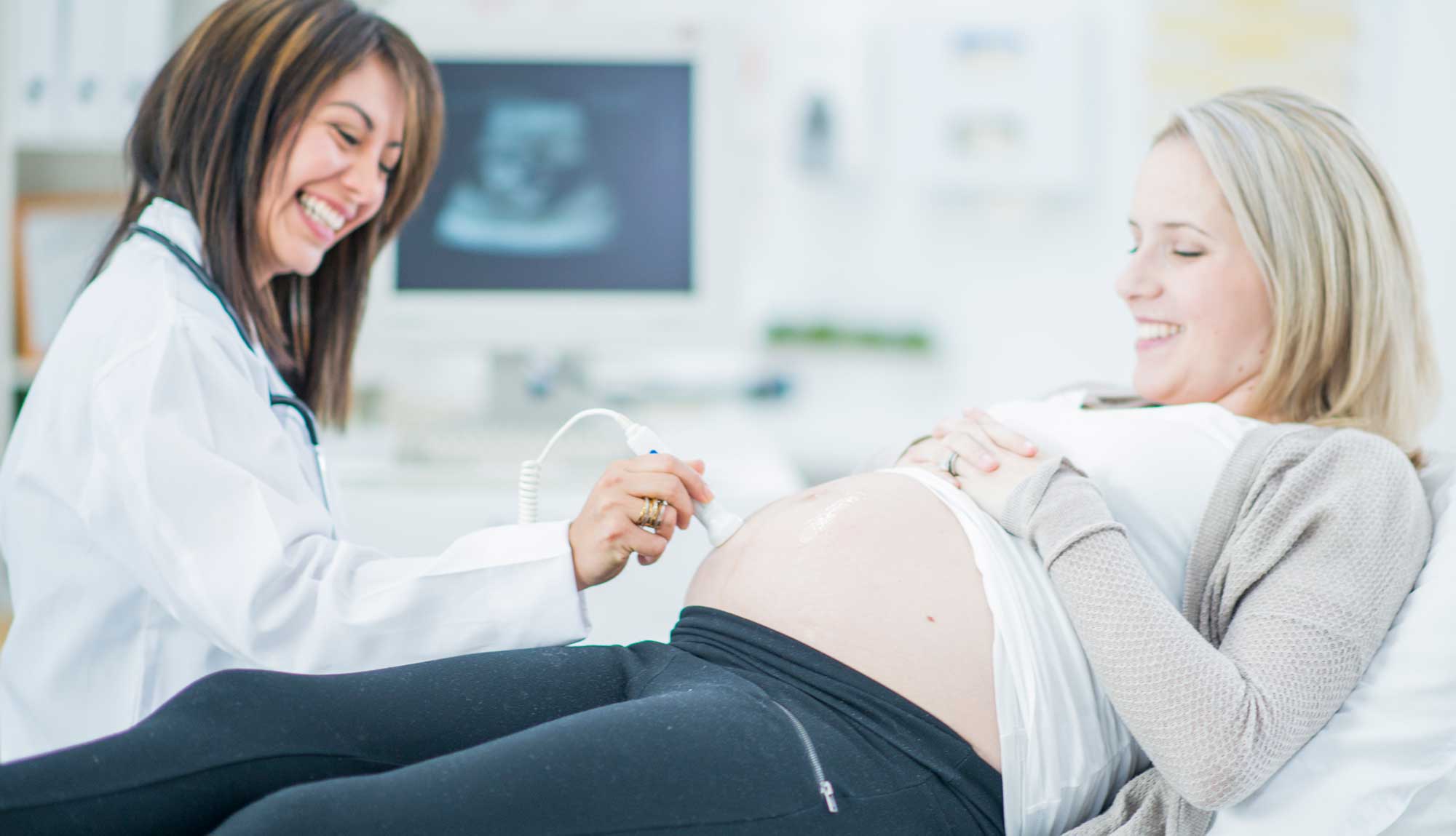 An OB-GYN resident performs an ultrasound on a pregnant patient.