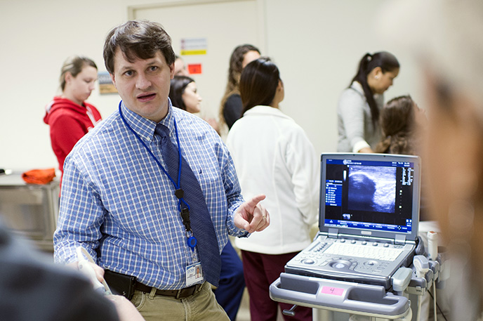 Dr. Craig Goodmurphy demonstrates ultrasound use to students.