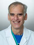 David Spiegel, MD, smiling at the camera and wearing his white medical coat.