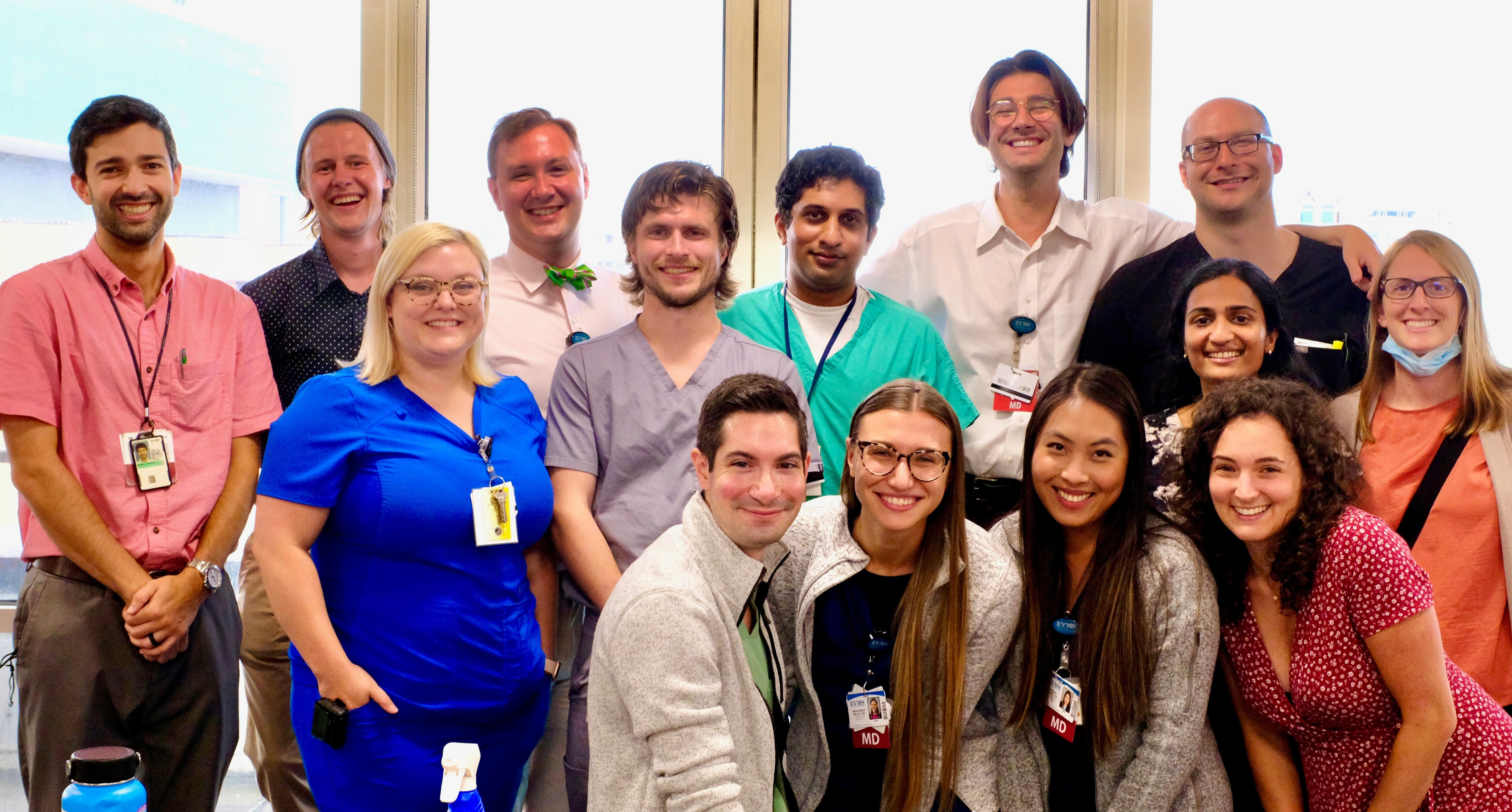 More than a dozen male and female psychiatry residents gather smiling in a group