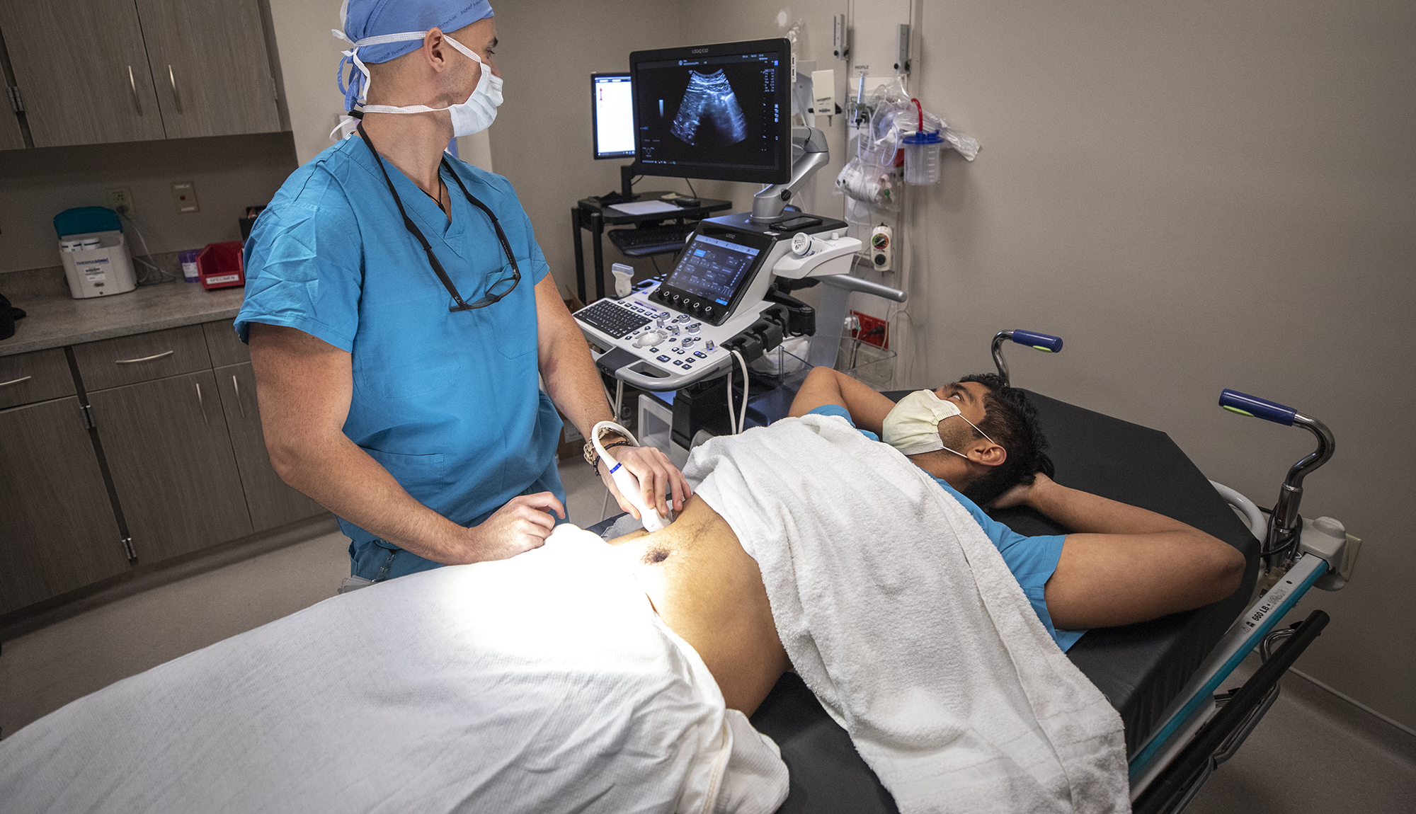 Radiologist performing ultrasound on a patient's abdomen