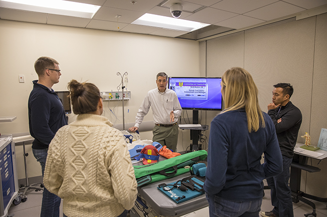Learners gather and discuss spinal cord injury in the Sentara Center for Simulation and Immersive Learning.