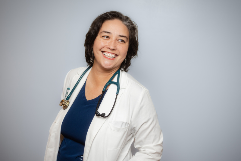 Woman smiling in white medical coat