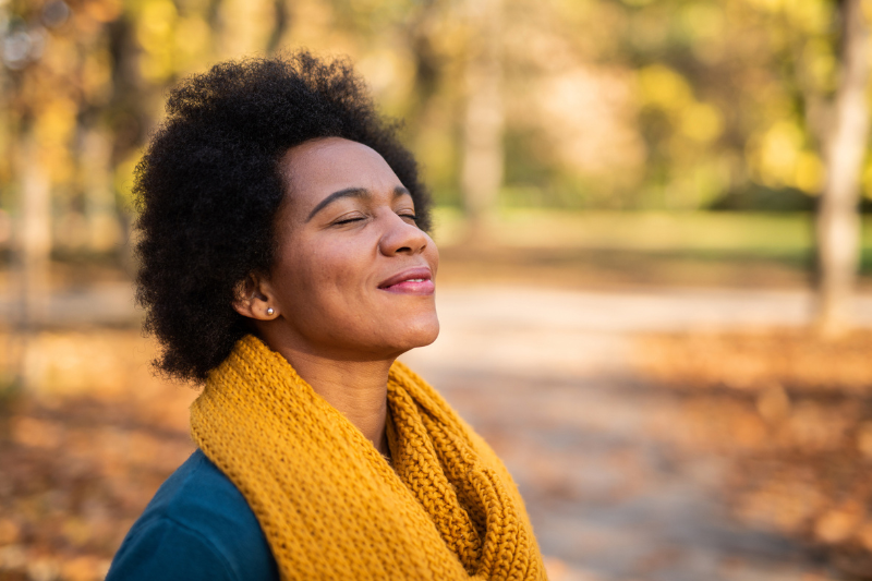 Woman smiling with fall leaves in background