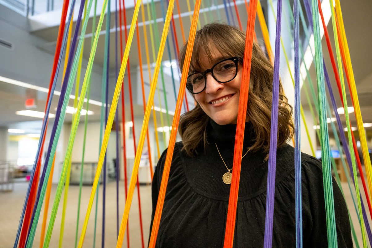 EVMS student Kim McCoy stands with her new art installation in Old Dominion University’s Perry Library