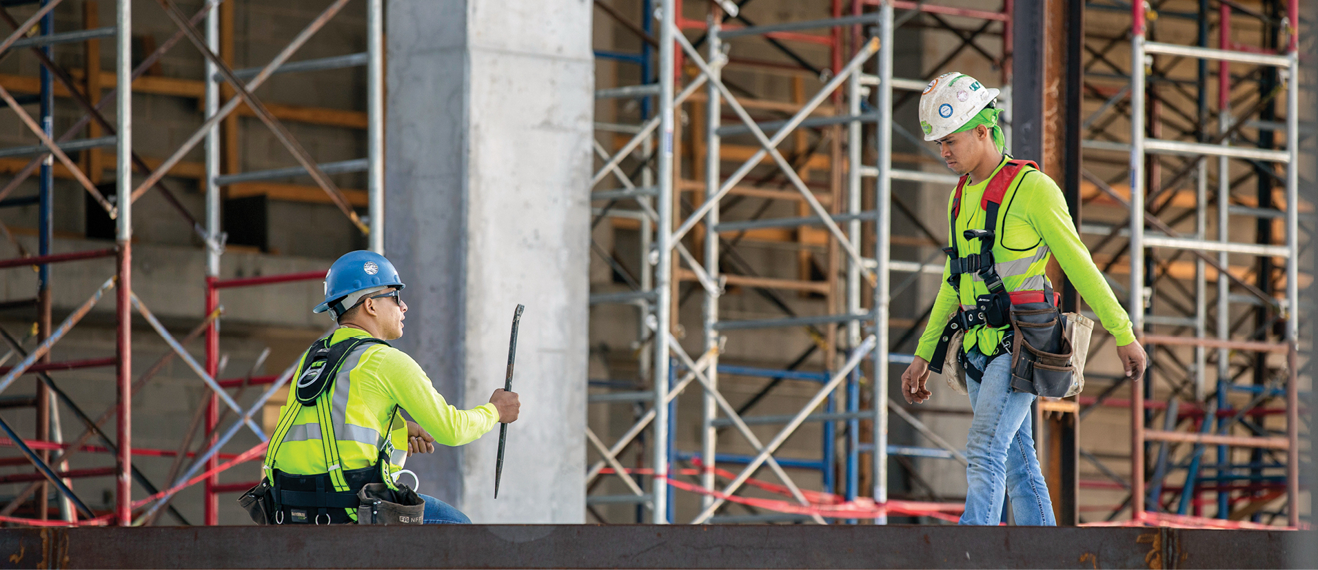Iron workers prepare the framework of the three-story podium that will provide much-needed classroom space.