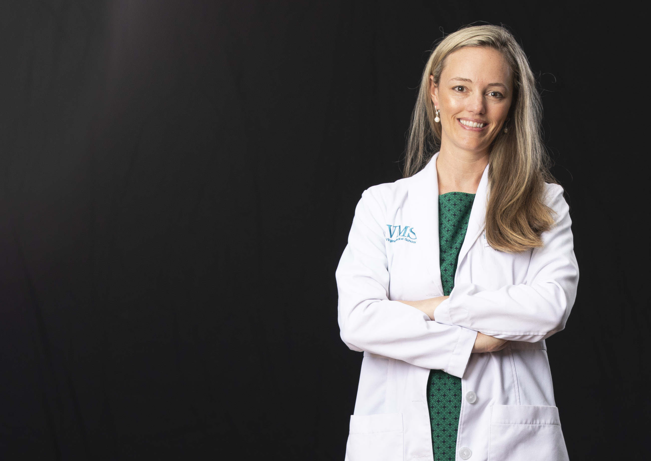 Dr. Brooke Hooper sits with her chin resting on her right hand and her legs crossed at the knees.