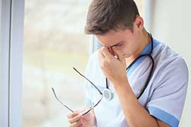 Stressed man rubbing his temples