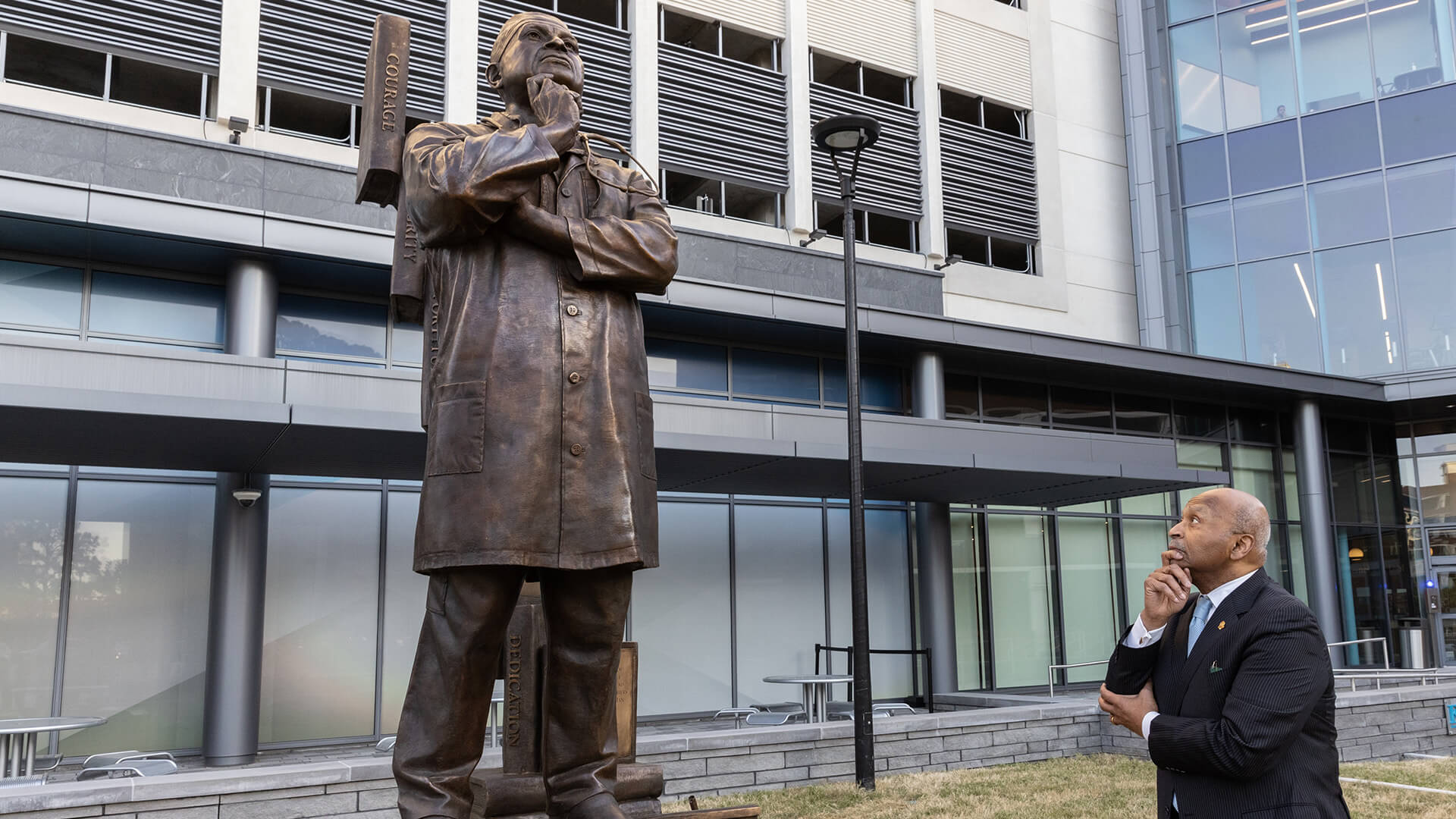 Dr. Britt posing in front of his statue