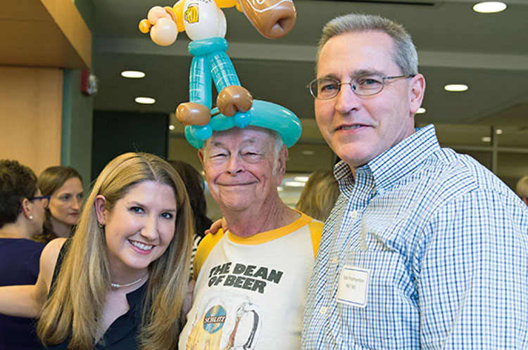 Jennifer Mueller, MD  (MD ’05) and Todd Palmerton, MD (MD ’85), posed for photos with former Dean of Students Robert McCombs, PhD.