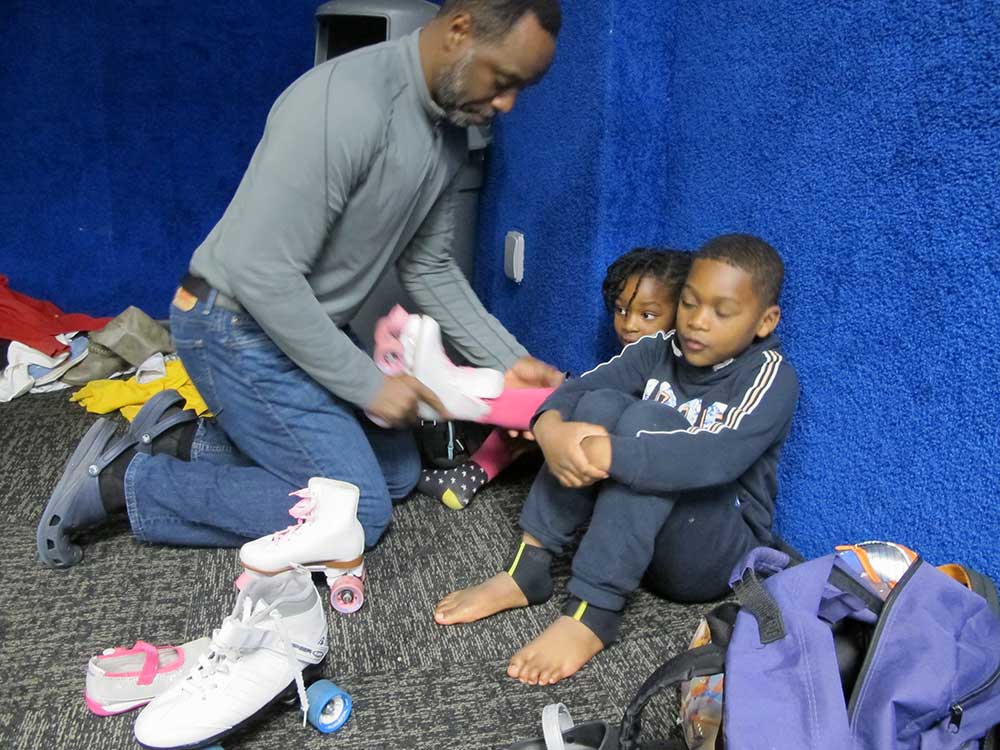 Dr. Salkey's husbands helps their children take off their skates.